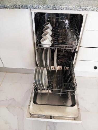 an open dishwasher with dishes inside of it at Vivienda del Sol in Costa Calma