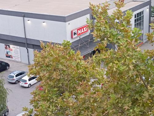 a mall with cars parked in a parking lot at Apartman Veki in Subotica