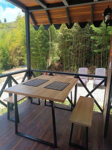 a wooden table and two chairs on a deck at Cabaña Momotus II in Concepción