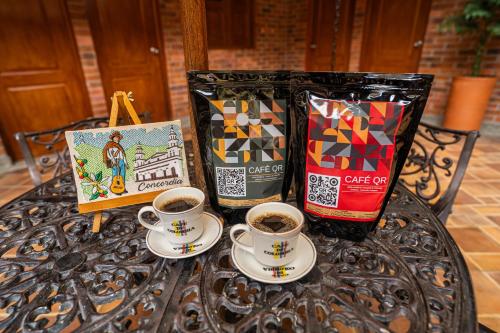 een tafel met twee kopjes koffie en een zak koffie bij HOTEL MONTE VERDE in Concordia