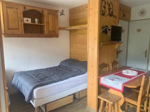 une petite chambre avec un lit et une table dans l'établissement Appart cosy avec balcon pour 4 personnes aux Menuires - FR-1-452-137, aux Menuires