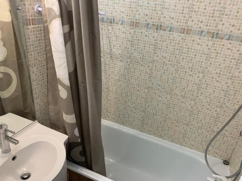une salle de bain avec un rideau de douche et un lavabo dans l'établissement Appart cosy avec balcon pour 4 personnes aux Menuires - FR-1-452-137, aux Menuires