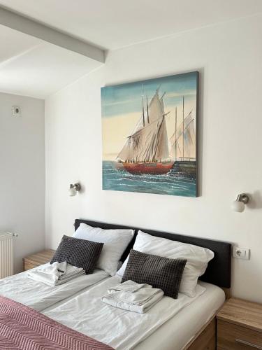 a bedroom with a large painting of a sail boat at Apartments Velickovic in Soko Banja