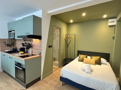 une chambre avec un grand lit et une cuisine dans l'établissement Le Pompery, à 500m du centre de Valence, à Valence