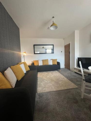 a living room with a black couch and a television at Simonside Apartment in Walker Gate