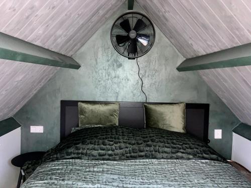 a bedroom with a bed and a clock on the wall at Landelijk gelegen huisje in Opperdoes