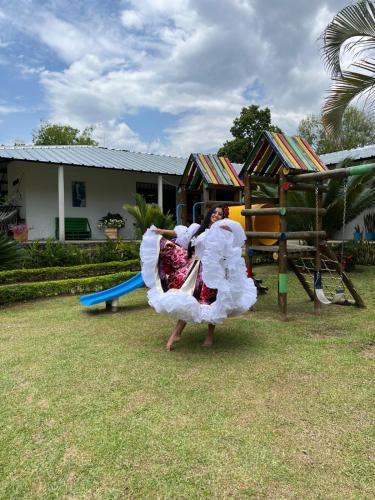 a woman in a dress playing on a playground at Finca Santa Clara, Rivera-Huila in Rivera