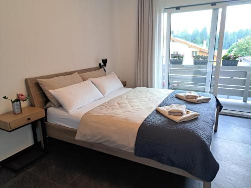 a bedroom with a bed with two towels on it at Ferienhaus LebensART in Bischofswiesen