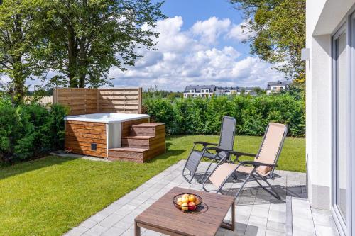 a backyard with a barbecue and a table and chairs at Willa z jacuzzi na polu golfowym Sierra Golf Homessimo Stars in Gowino