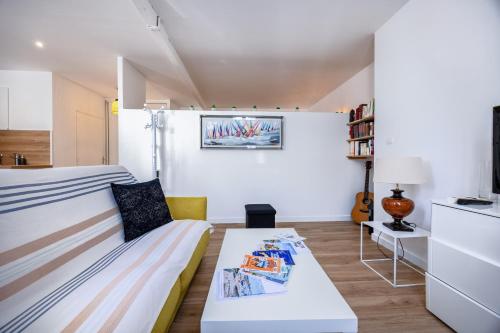 Cette petite chambre comprend un canapé et une table. dans l'établissement Charmante Maisonnette à deux pas de la plage, à Châtelaillon-Plage
