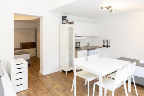 a kitchen and dining room with a white table and chairs at Z.Bilić V&V in Jesteburg