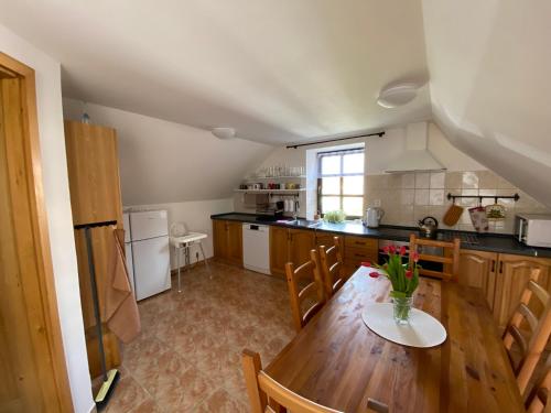 a kitchen with a wooden table with a vase of flowers on it at Chalupa U brouka in Nová Bystřice