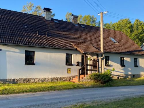 a white house with a brown roof at Chalupa U brouka in Nová Bystřice