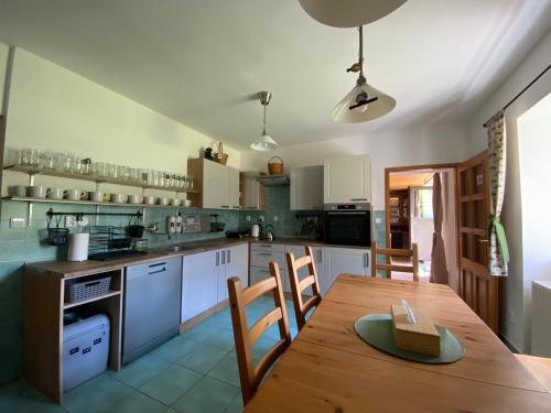 a large kitchen with a wooden table and chairs at Chalupa U brouka in Nová Bystřice