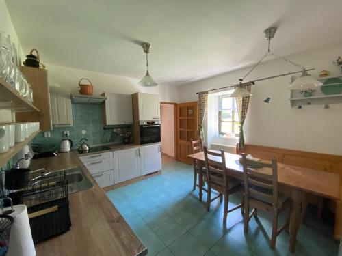 a kitchen with a wooden table and chairs in it at Chalupa U brouka in Nová Bystřice