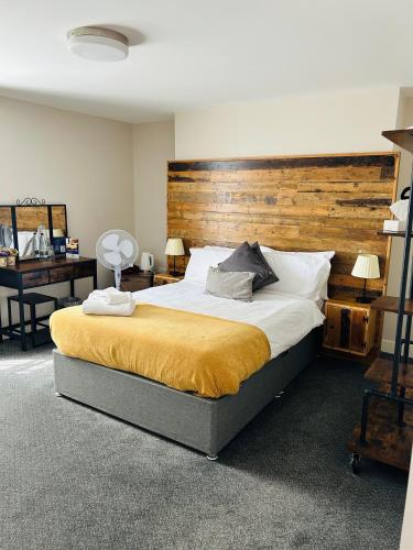 a bedroom with a large bed with a wooden headboard at The Brookmill in London