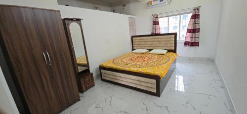 a small bedroom with a bed and a mirror at Panihati Village in Pānihāti