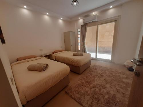 a bedroom with two beds and a window at New Cairo Zoé in Cairo