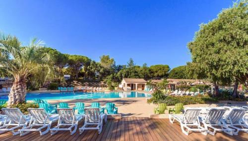 - un groupe de chaises blanches et une piscine dans l'établissement Chalet Coco, à Roquebrune-sur Argens