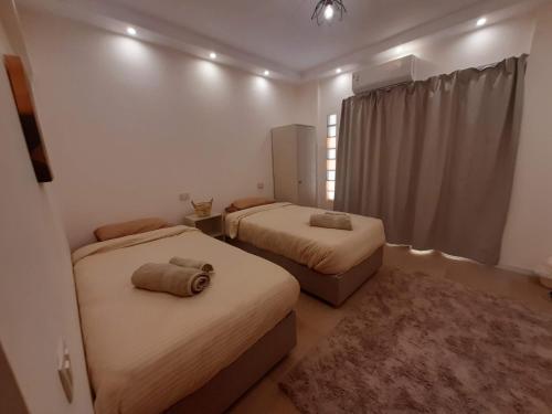 a bedroom with two beds and a window at New Cairo Zoé in Cairo