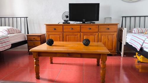 a bedroom with a wooden dresser with a tv on it at Family Stone House with Sea View and Parking - Pets welcome in Podgora