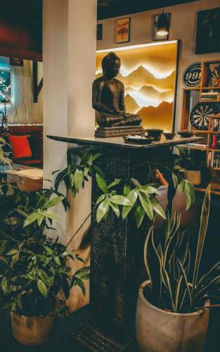 a statue sitting on top of a table with plants at CITYSCAPE YALA BY 999 HOTEL & RESTAURANT in Tissamaharama