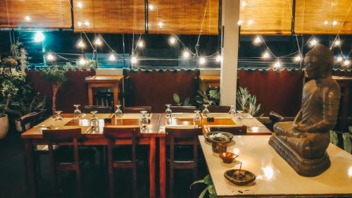 a restaurant with tables and a statue in the middle at CITYSCAPE YALA BY 999 HOTEL & RESTAURANT in Tissamaharama