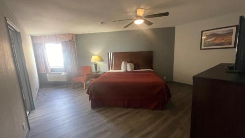 a hotel room with a bed and a window at Days Inn & Suites by Wyndham Winnie in Winnie