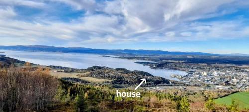 a house on a hill next to a body of water at Holiday home in Steinkjer in Steinkjer