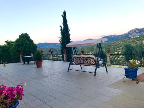 a patio with a bench and an umbrella at La Almedina: Palacio de Foronda in Cazorla