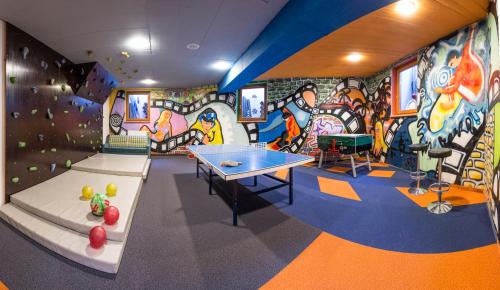 a room with a ping pong table and graffiti at Harmls Aparthotel in Flachau