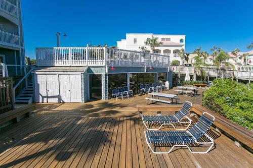 a deck with two chairs and a table and benches at Beachfront Gem Core of St Augustine in Saint Augustine
