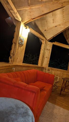 a red couch sitting in a room with some hay at Olemayian Amboseli Cottages in Kimana
