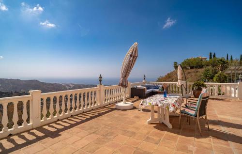 een patio met een tafel en een parasol op een balkon bij 1 Bedroom Gorgeous Home In Arenas in Arenas