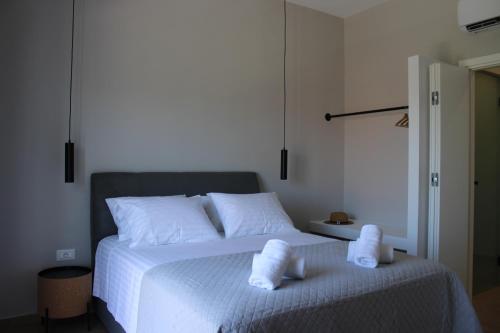 a bedroom with a white bed with towels on it at Modern Living Kefalonia in Lakíthra