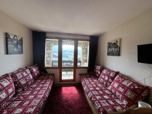 - un salon avec des canapés rouges et une fenêtre dans l'établissement Résidence Andromede - 2 Pièces pour 5 Personnes 03, à Mâcot La Plagne