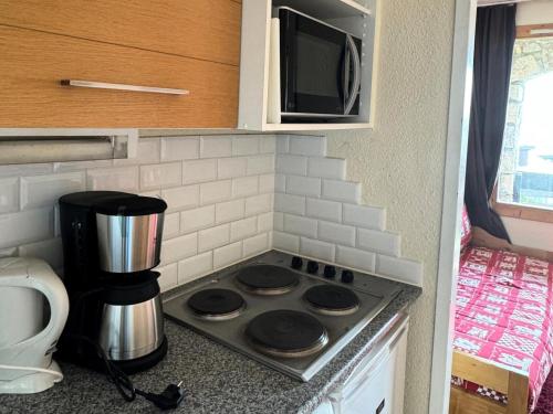 Il comprend une cuisine équipée d'une cuisinière et d'un four micro-ondes. dans l'établissement Résidence Andromede - 2 Pièces pour 5 Personnes 03, à Mâcot La Plagne