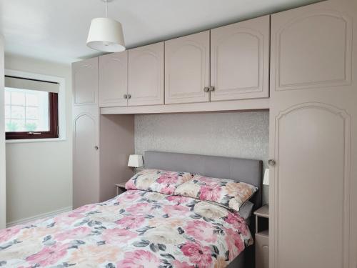 a bedroom with a bed with a floral bedspread at Modern town centre apartment in Tobercurry