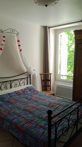 une chambre avec un lit et une fenêtre dans l'établissement Le moulin, à Lasalle