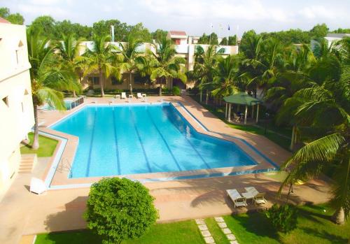 an overhead view of a swimming pool with palm trees at Hotel Ghis Palace in Baguida