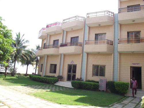 a building with people standing outside of it at Hotel Ghis Palace in Baguida