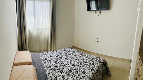 a bedroom with a bed with a black and white blanket at Habitación con cama matrimonial in Villahermosa
