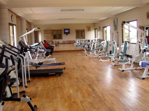 un gimnasio con filas de cintas de correr y equipos de pilates en Hotel Ghis Palace, en Baguida