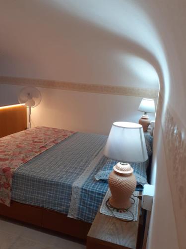 a bedroom with a bed and a lamp on a table at Centro Storico Portoferraio in Portoferraio