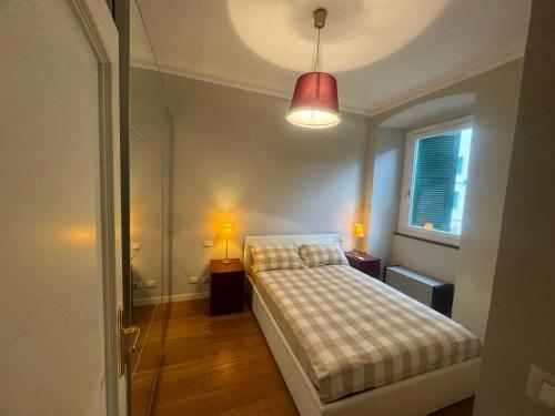 a bedroom with a bed and a lamp and a window at Casa Nina Carignano in Genoa