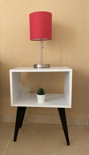 a white desk with a lamp and a plant on it at CASABONITA fte alberca, AirAc in Alpuyeca