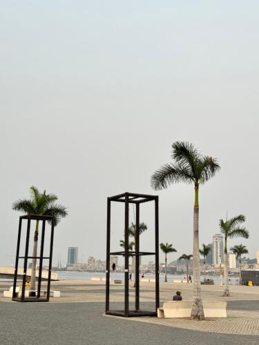 a park with two swings and palm trees on a beach at Peaceful and Spacious Apartment at Luanda Bay in Luanda