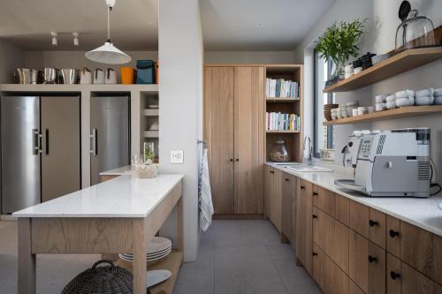 a kitchen with wooden cabinets and a white counter top at Romansbaai Collection in Gansbaai