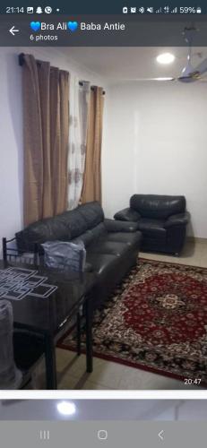 a living room with a black couch and a table at Spritex Road in Ablekuma