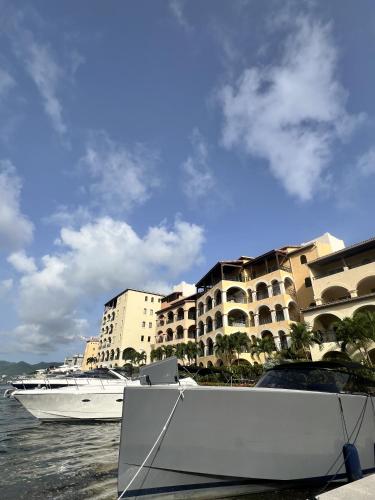 a boat in the water next to some buildings at Luxury Marina & Sea View Condo at Porto Cupecoy St Maarten in Lowlands